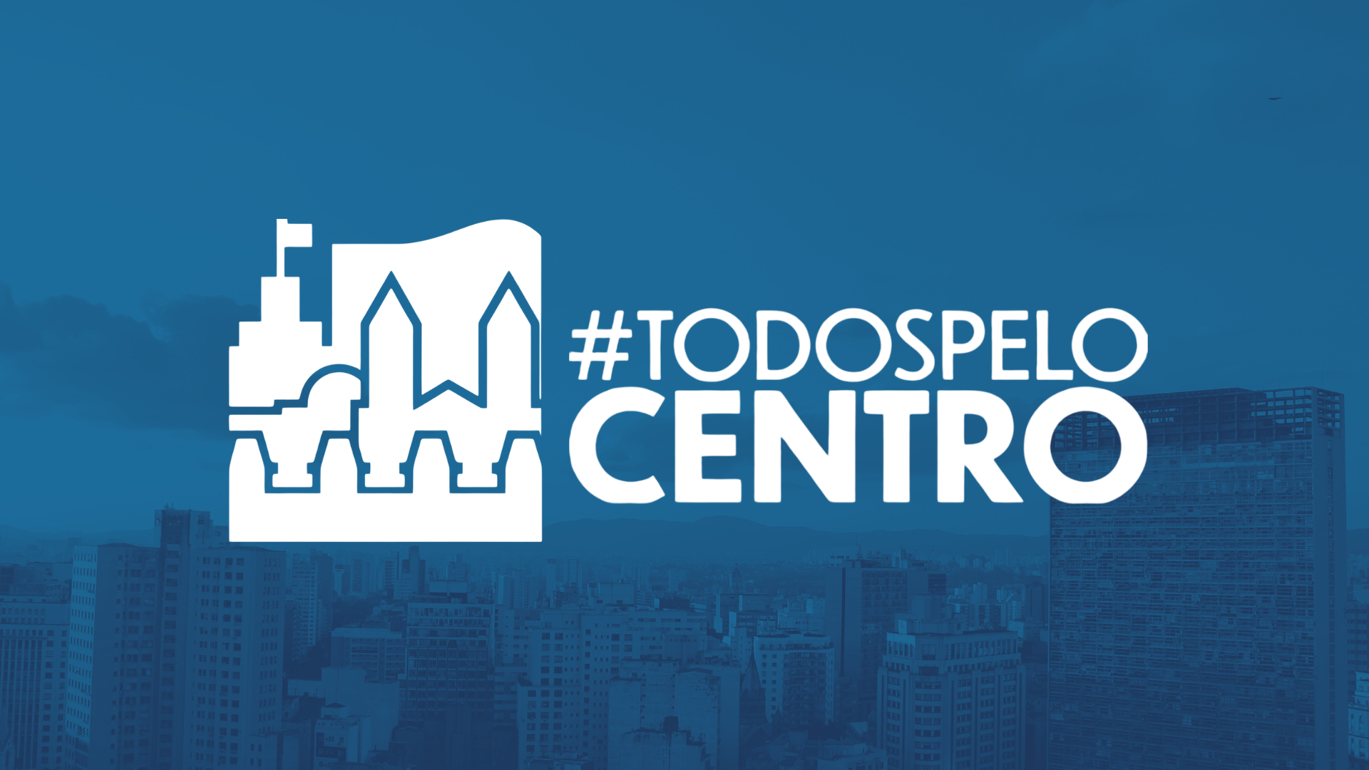 A imagem apresenta um plano de fundo azul sobreposto a uma fotografia aérea de uma grande metrópole em tons monocromáticos, exibindo diversos prédios e edifícios sob um céu com algumas nuvens. No centro da composição, destaca-se em branco um logotipo composto por um ícone à esquerda, que traz ilustrações estilizadas de monumentos arquitetônicos como uma torre com bandeira e fachadas de prédios históricos, e um texto à direita, onde se lê a hashtag #TODOSPELO em letras maiúsculas, posicionada logo acima da palavra CENTRO, escrita em uma fonte maior e mais robusta. O conjunto visual sugere uma campanha de mobilização social ou institucional voltada para a valorização da região central da cidade.